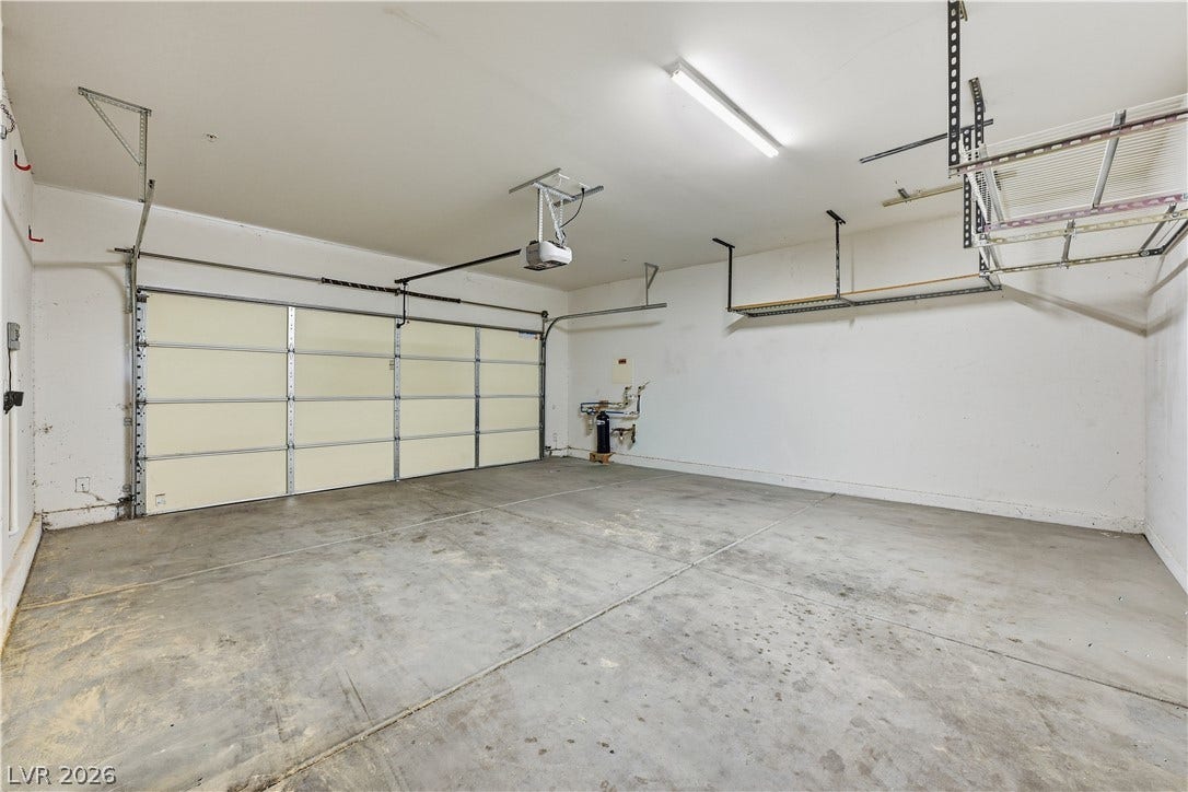 1122 Bradley Bay Avenue, Henderson, NV 89014 Concrete flooring and built-in overhead storage shelves define this functional garage space.