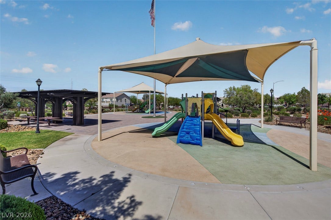 1122 Bradley Bay Avenue, Henderson, NV 89014 A shaded playground structure sits near a covered picnic area with paved concrete pathways.