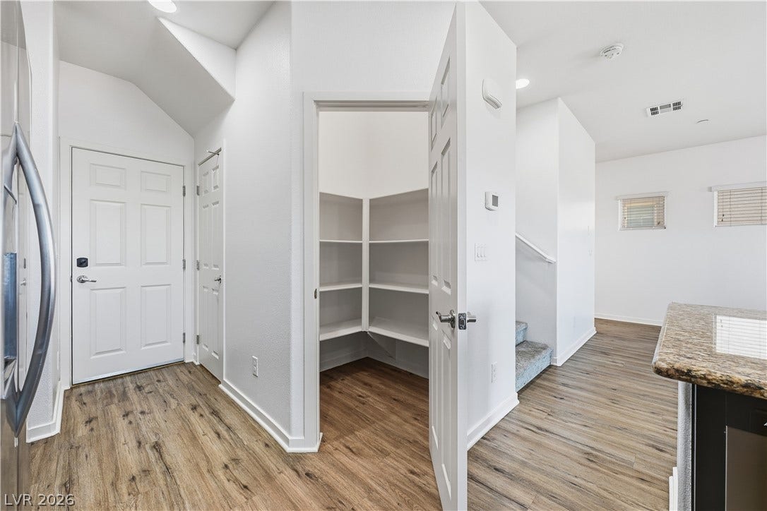 1122 Bradley Bay Avenue, Henderson, NV 89014 A built-in pantry with wrap-around shelving sits adjacent to the hallway and kitchen areas.