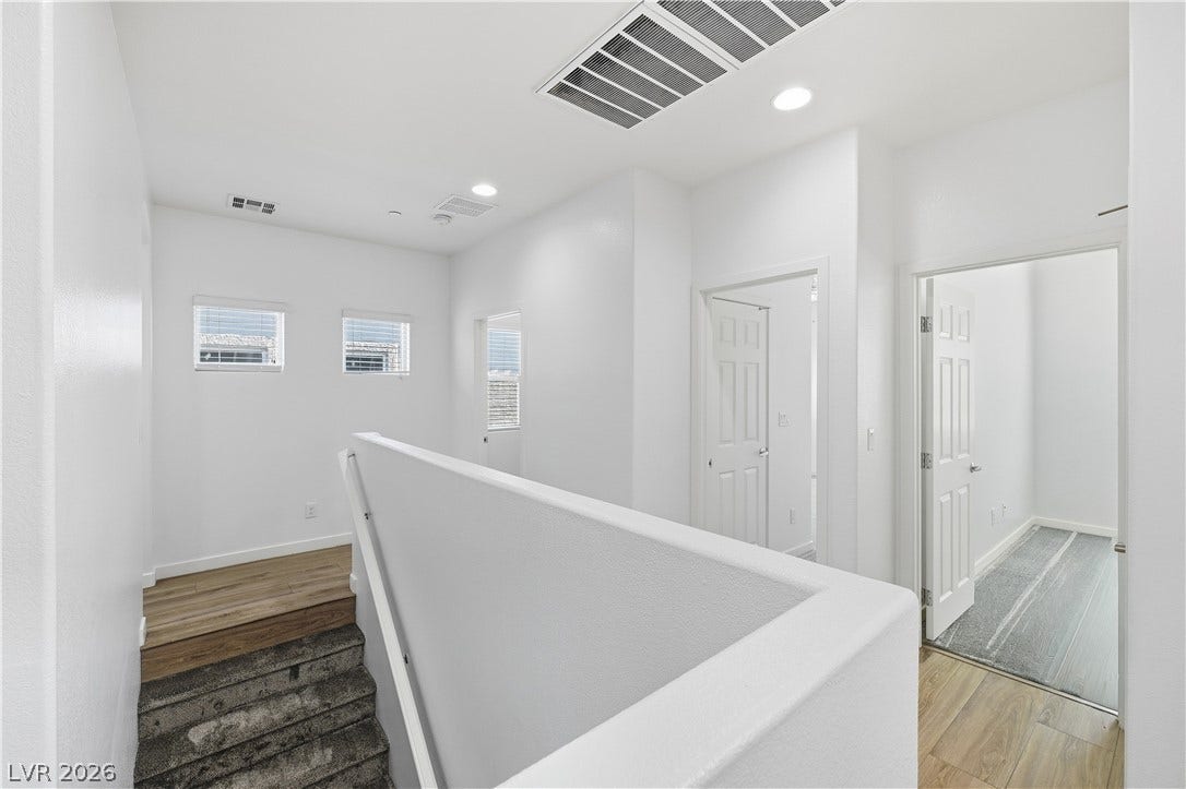 1122 Bradley Bay Avenue, Henderson, NV 89014 An upper-level landing connects several rooms with sleek flooring and recessed lighting.