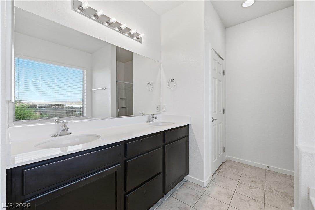 1122 Bradley Bay Avenue, Henderson, NV 89014 Clean lines and a spacious dual vanity define this bright bathroom with tile flooring.