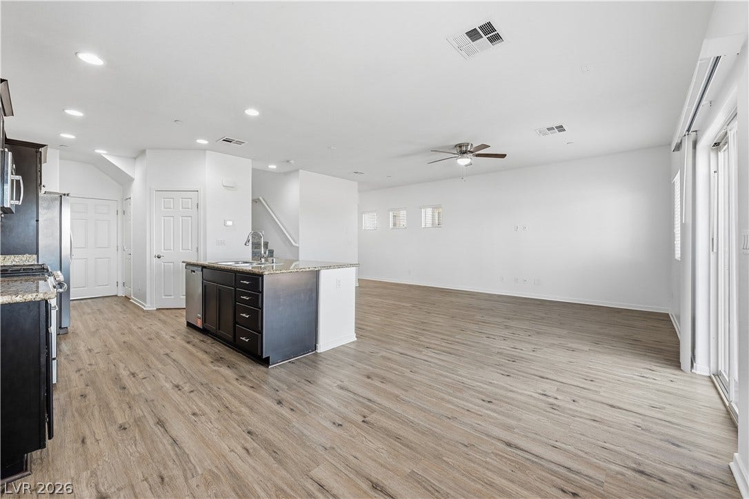 1122 Bradley Bay Avenue, Henderson, NV 89014 An open floorplan seamlessly connects the kitchen and main living area over handsome wood-look flooring.