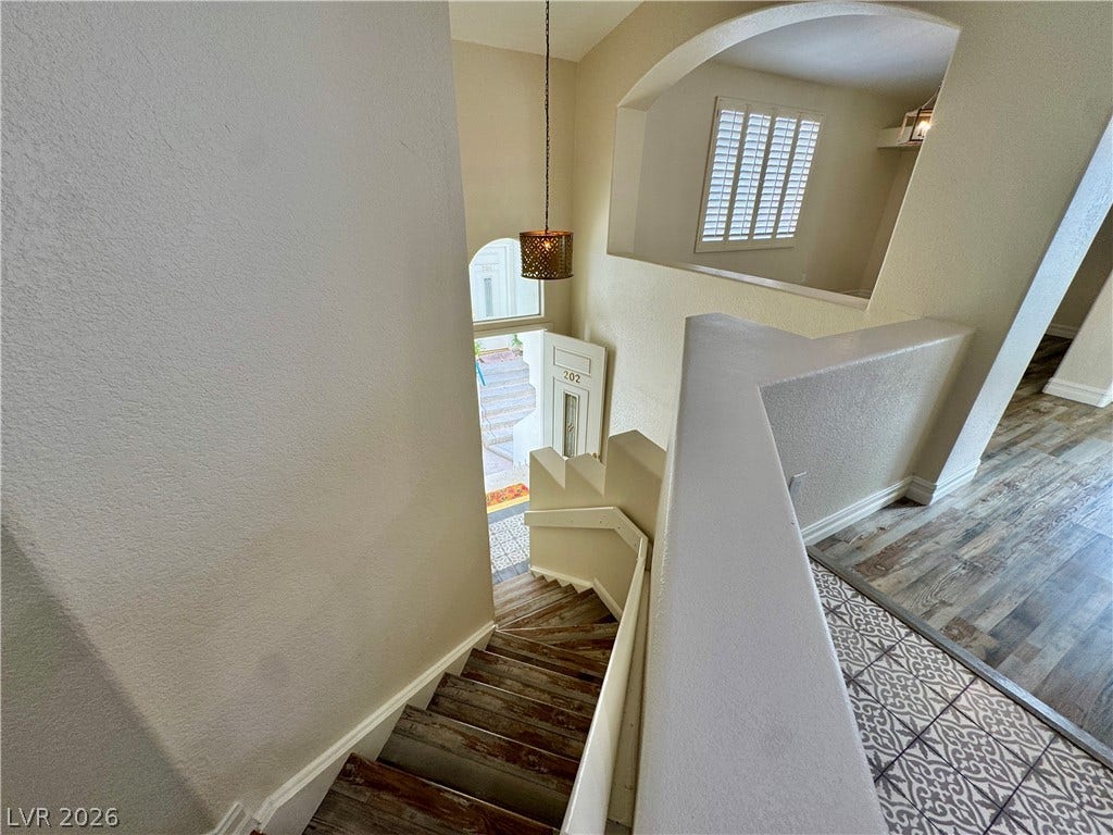 An airy multi-level staircase connects beautifully tiled landings under high ceilings with architectural archways.