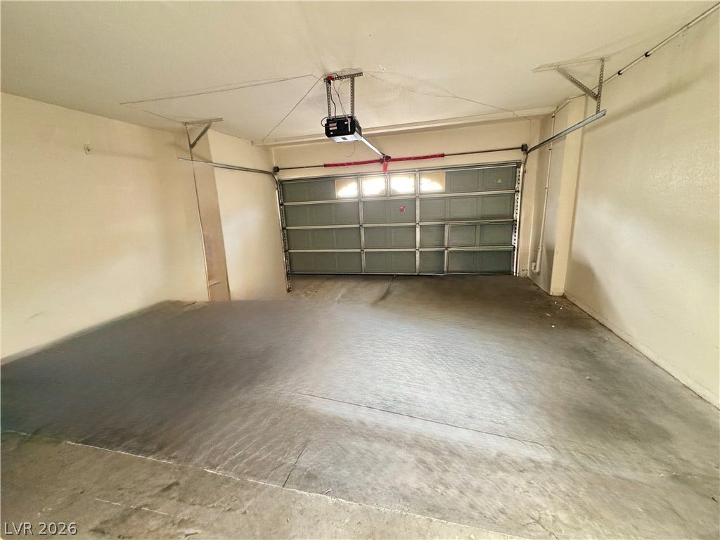 Smooth concrete floors and a wide automatic door define this clean garage space.