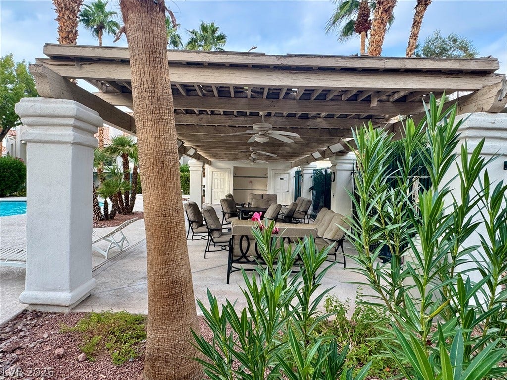 An expansive shaded patio structure provides a comfortable retreat adjacent to the community pool.