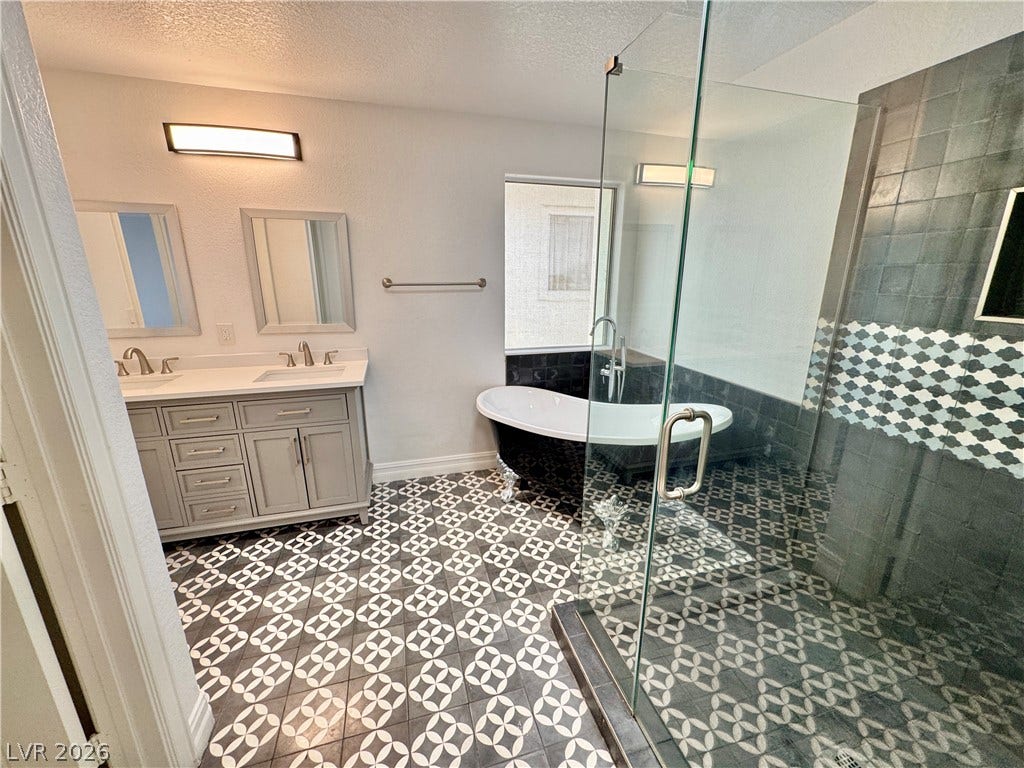 Patterned tile flooring and a clawfoot tub anchor this sleek modern bathroom.