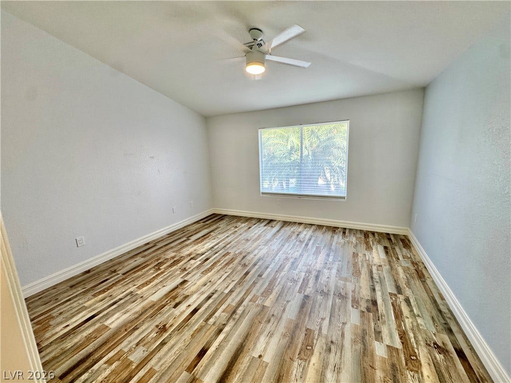Gleaming wood-look floors and vaulted ceilings elevate this light-filled room.