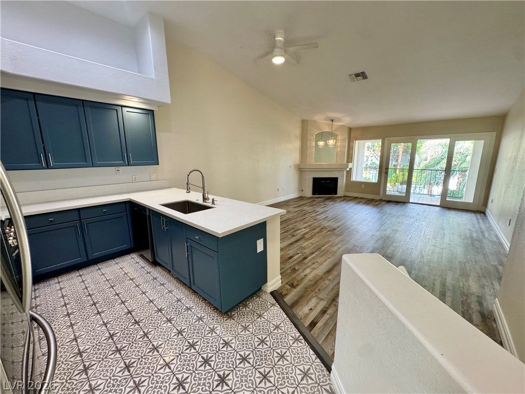 An open floor plan connects the kitchen and living area under a vaulted ceiling.