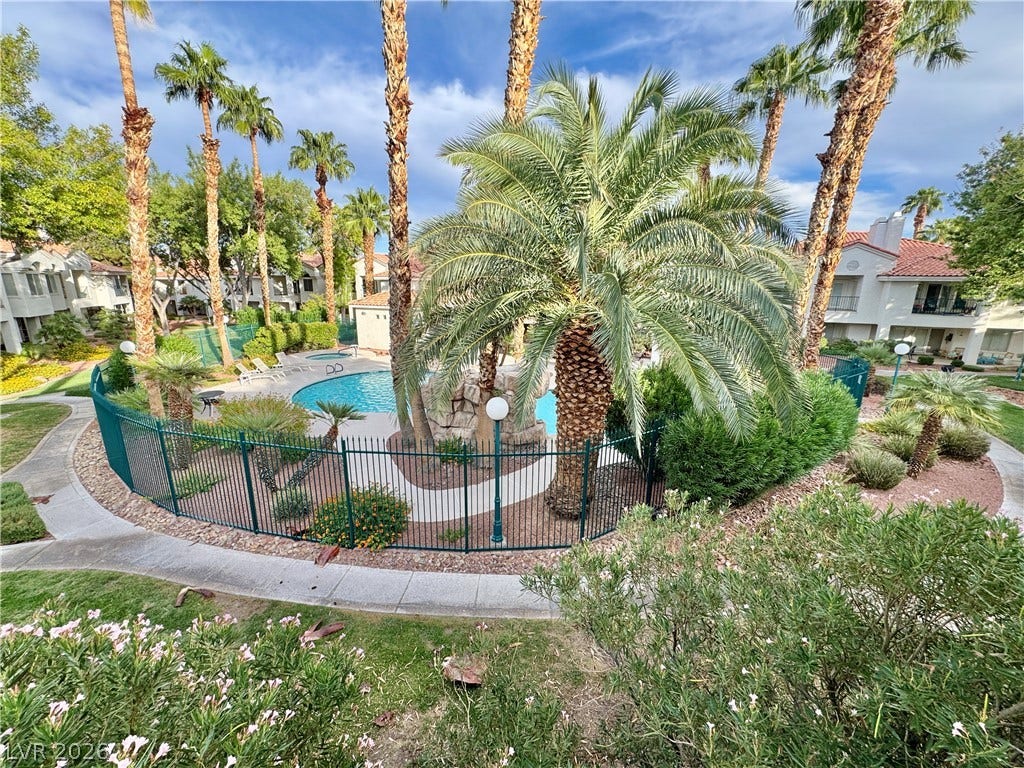 Lush tropical plantings and soaring palms surround the sparkling community swimming pool.
