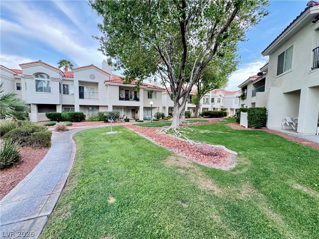 Manicured lawns and concrete walkways wind between classic stucco buildings.