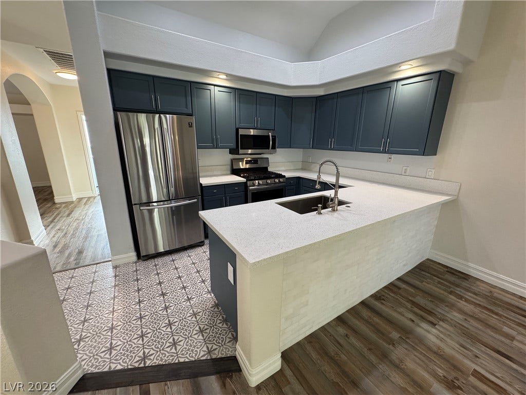 High vaulted ceilings and custom tile flooring elevate this updated kitchen workspace.
