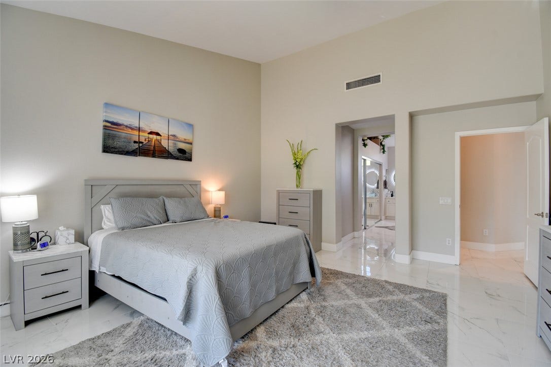 High ceilings and polished tile floors define this spacious bedroom suite.