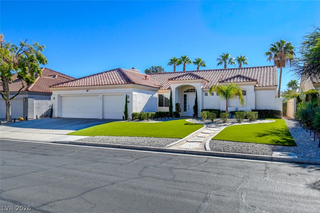 A classic tile roof and manicured front lawn define this elegant desert-style exterior.