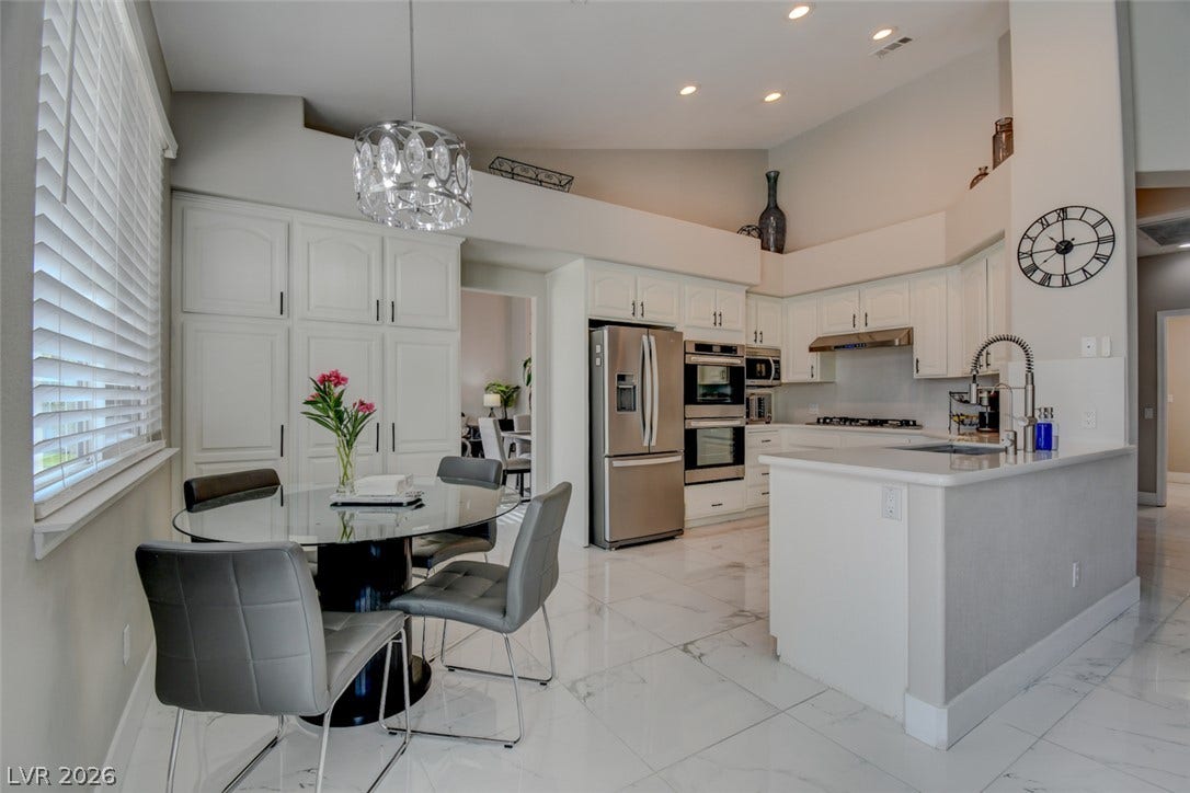 High ceilings and polished tile floors define this airy kitchen and casual dining area.