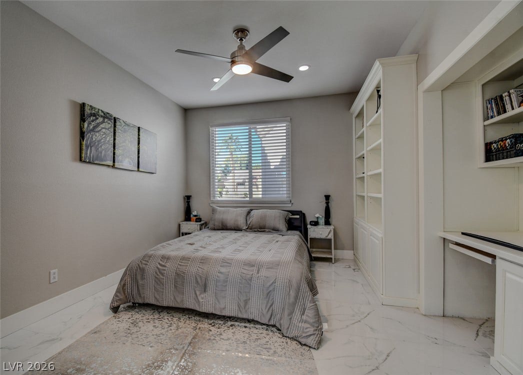 Polished tile flooring and custom built-in shelving define this versatile modern bedroom space.