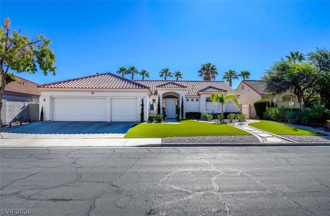 Classic desert styling pairs with a manicured front lawn and a tiled roofline.