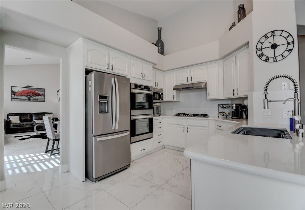 High ceilings and gleaming tile floors define this open, modern kitchen design.
