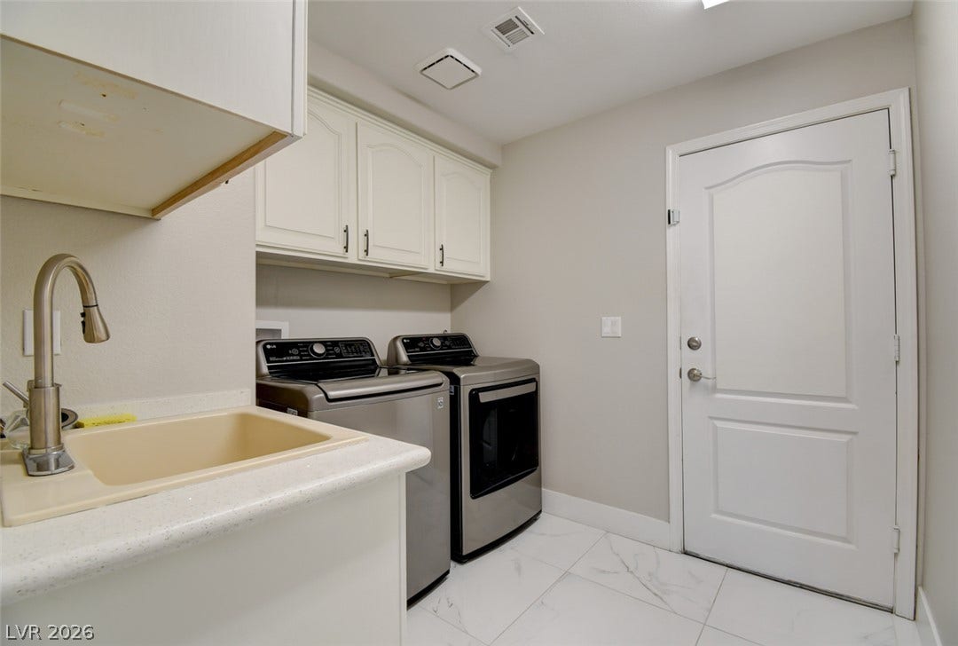 Functional cabinetry and polished tile floors define this dedicated utility space.
