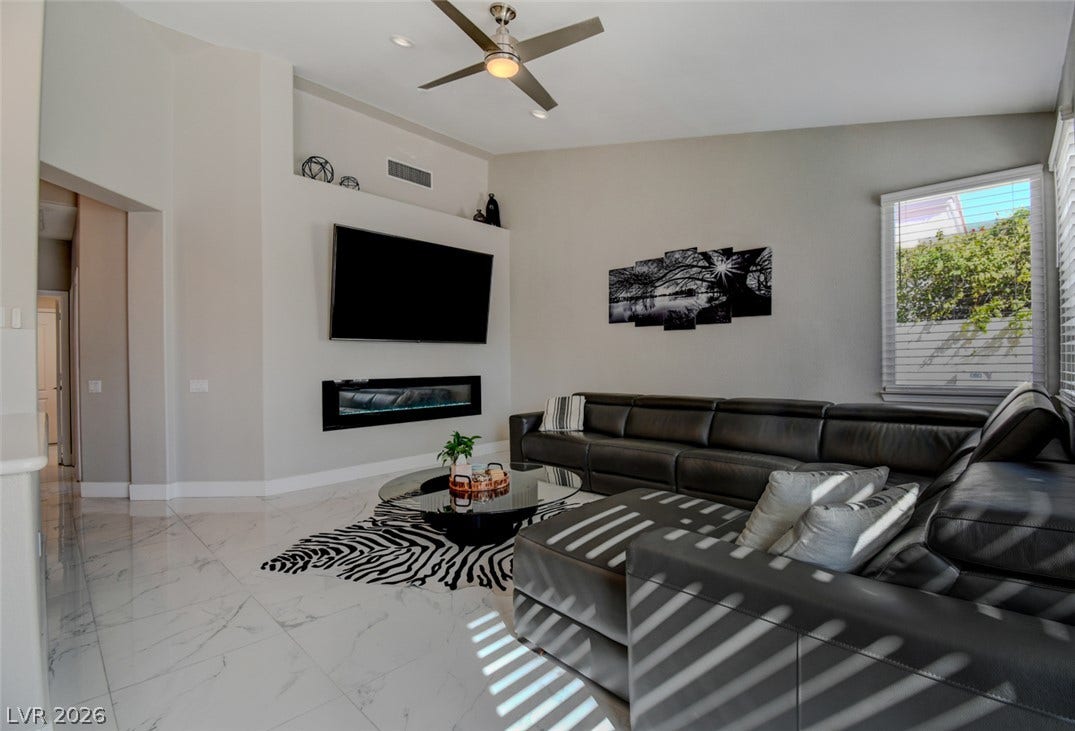 Gleaming tile floors and a sleek fireplace anchor this airy modern living space.