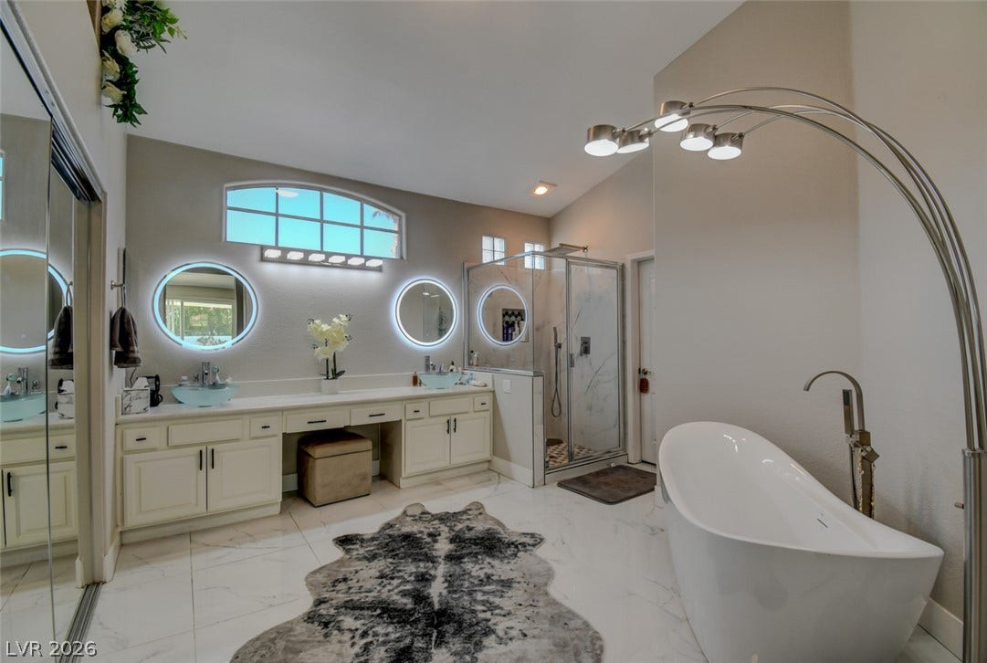 A freestanding soaking tub and dual vanities anchor this spacious primary bath retreat.