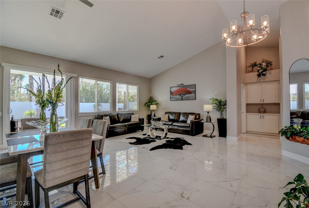 Gleaming polished tile floors reflect light beneath soaring vaulted ceilings in this airy open layout.
