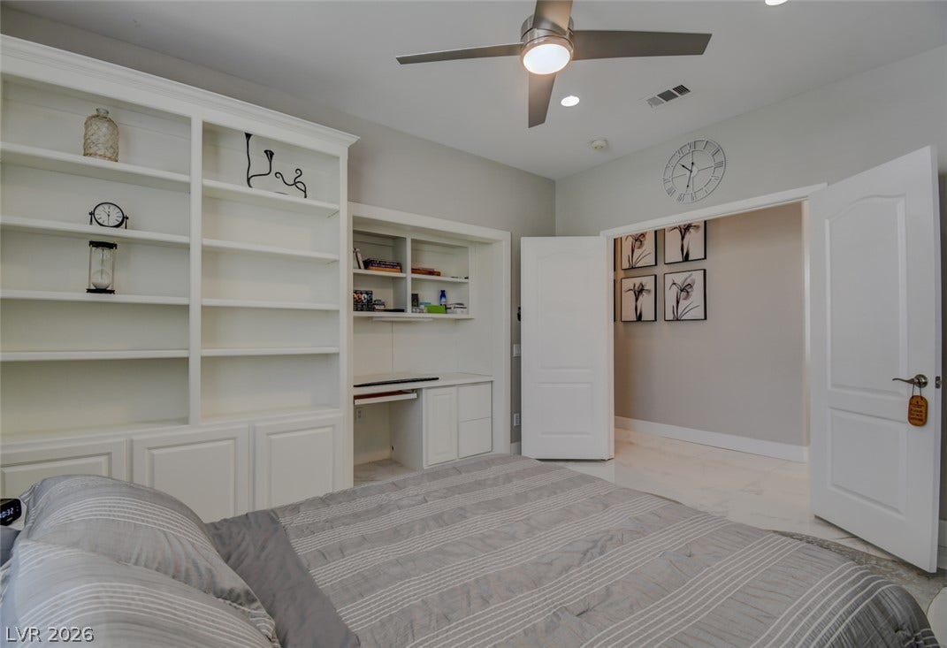 Custom built-in shelving and a dedicated desk nook elevate this bedroom space.