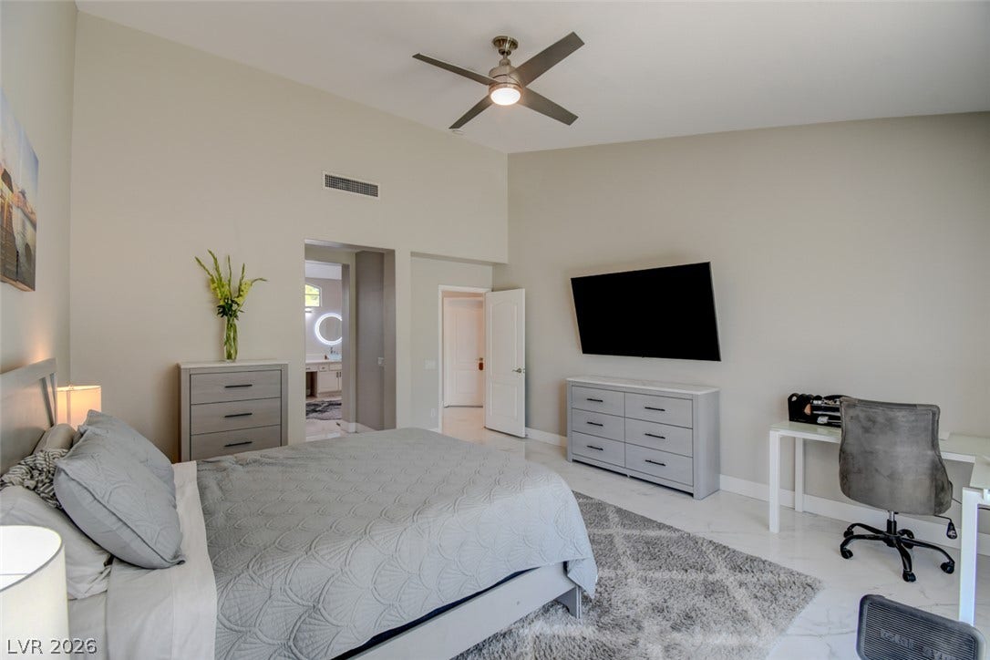Vaulted ceilings and sleek tile flooring elevate this spacious bedroom suite.