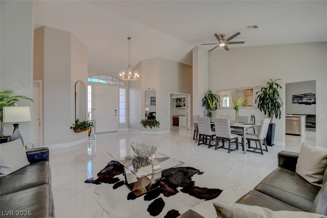 Polished tile flooring and high ceilings frame this grand, open-concept living and dining area.