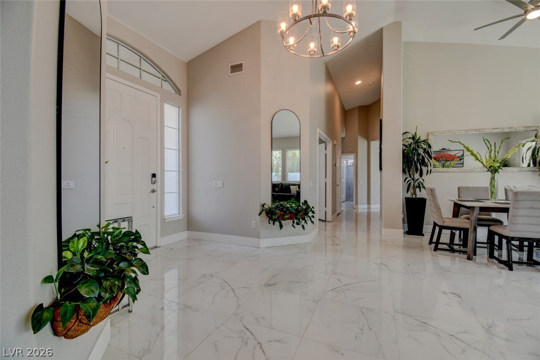 Polished tile flooring and high ceilings define this welcoming entrance foyer.