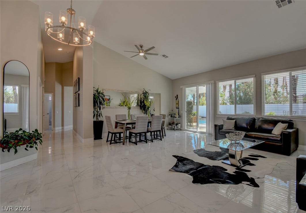 Gleaming polished tile floors and vaulted ceilings elevate this open-concept main living space.
