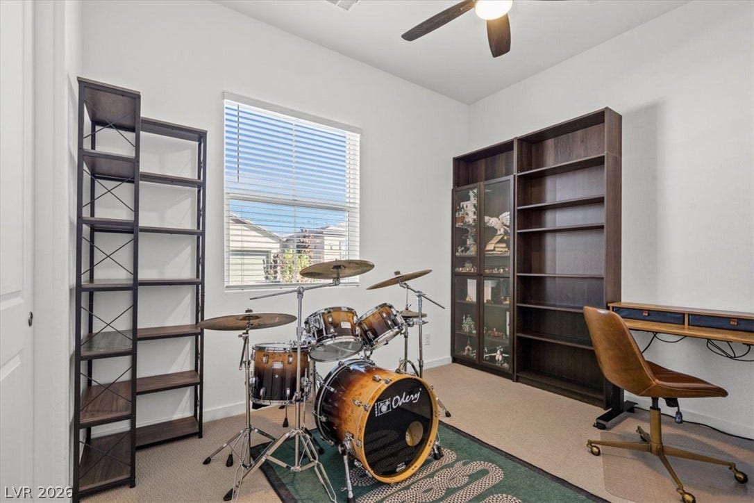 Natural light streams through a large window onto carpeted floors and neutral walls.