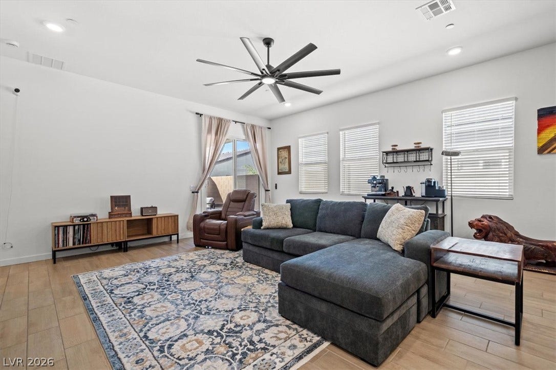 Recessed lighting and wood-look flooring enhance this inviting open living space.