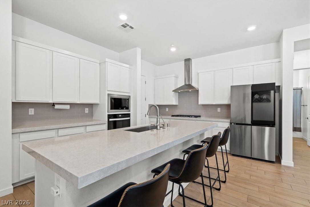 Gleaming stone countertops and modern built-in appliances anchor this spacious culinary workspace.