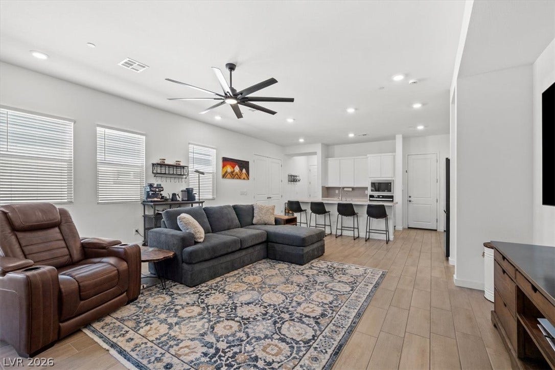An airy open layout integrates the living area with a modern kitchen island breakfast bar.
