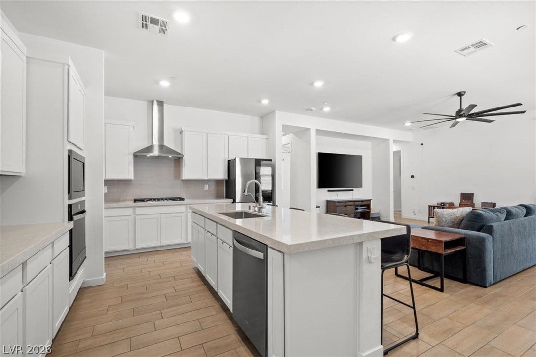 An open kitchen seamlessly connects to the living space over continuous tile floors.