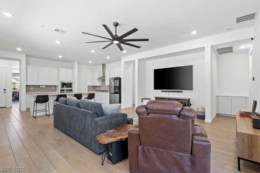 Clean lines and wood-look tile flooring define this airy open-concept living area.