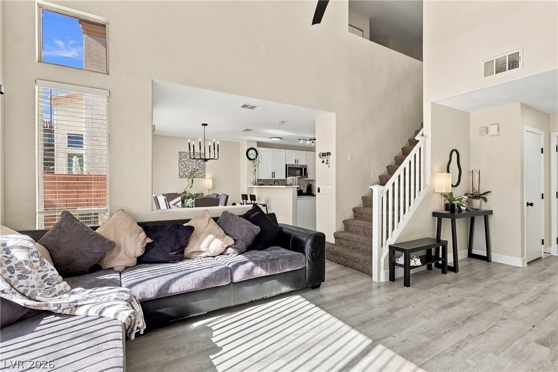 High ceilings and tall windows bring abundant natural light to this open living space.