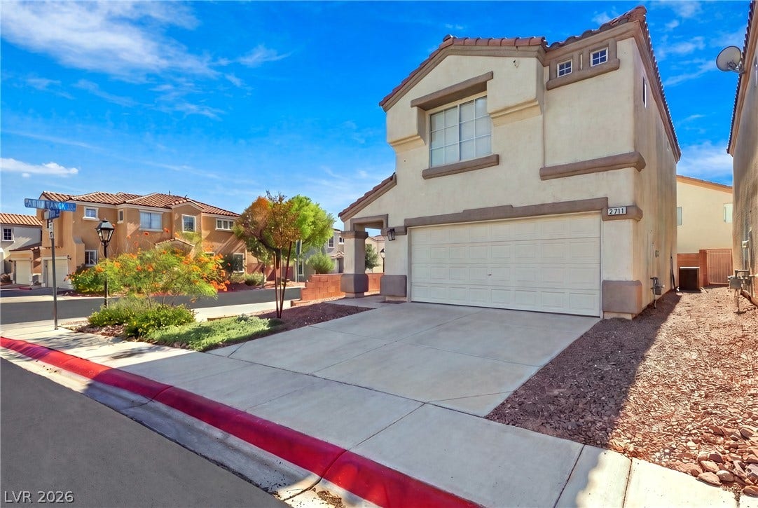 A spacious driveway leads directly to the integrated two-car garage of this multi-level home.