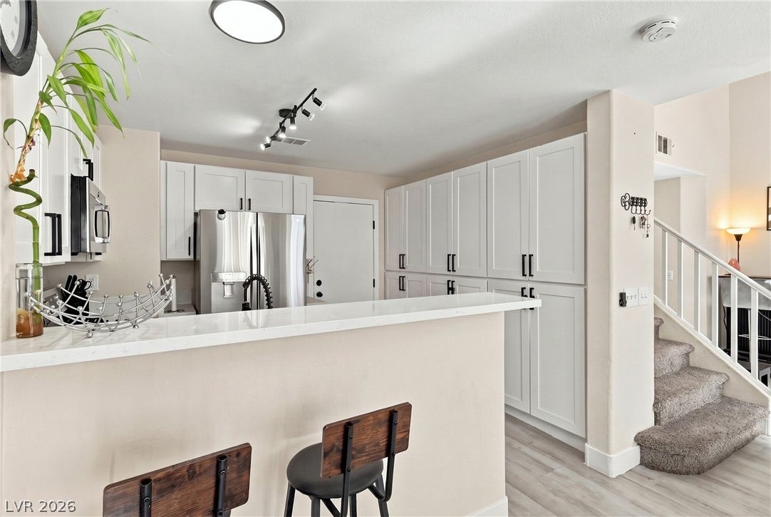 Gleaming stone countertops and matching cabinetry define this modern open kitchen layout.