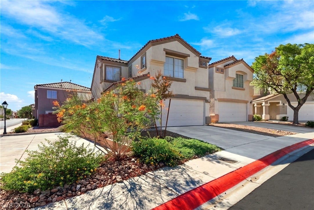 Mediterranean-inspired stucco exterior features tile roofing and integrated multi-car garages.