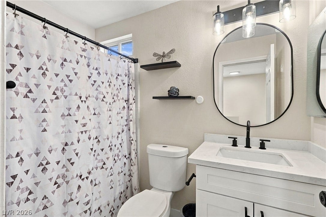 Modern fixtures and stone counters elevate this updated bathroom space.