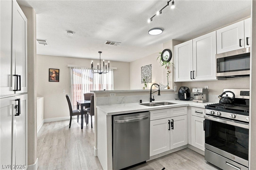 Streamlined cabinetry and sleek solid-surface countertops flow into an adjacent dining area.
