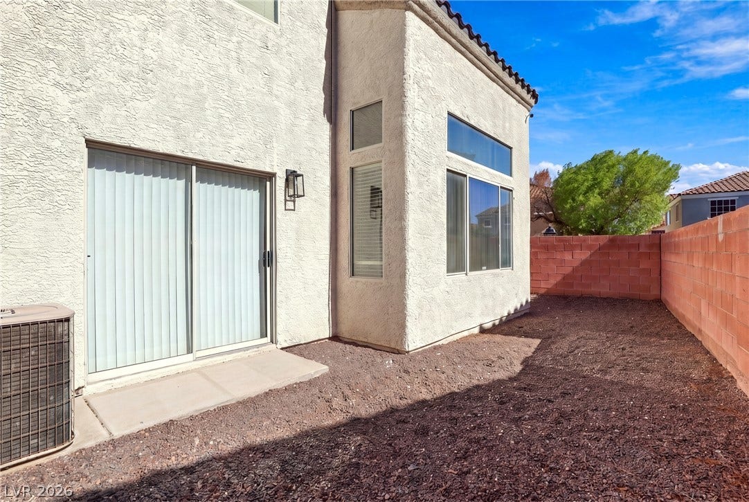 Stucco exterior finishes and sliding glass doors look out onto a private yard.