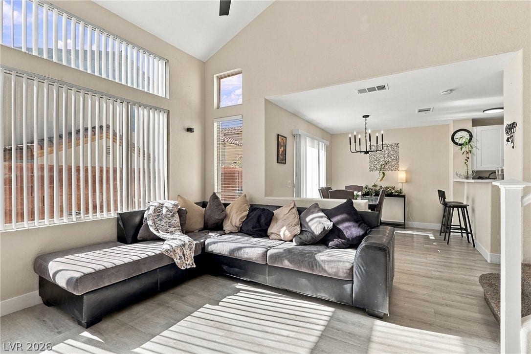 Vaulted ceilings and wood-style flooring elevate this bright, open-concept living space.