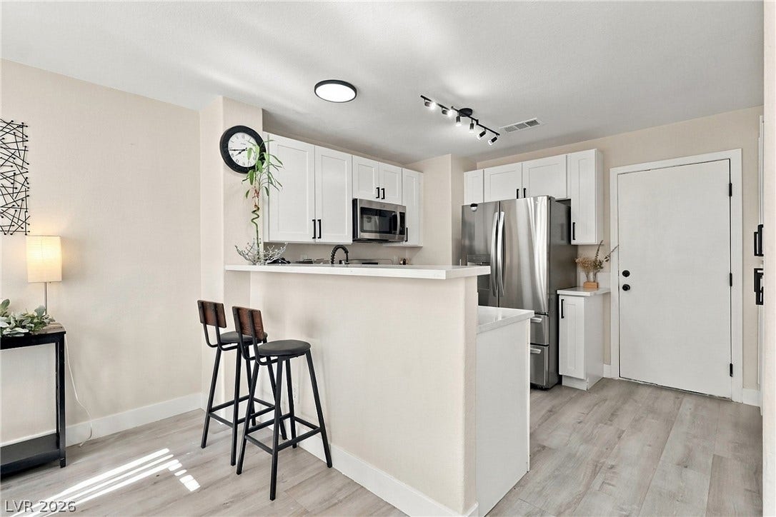 Gleaming wood-look floors pair beautifully with crisp white cabinetry and stainless steel appliances.