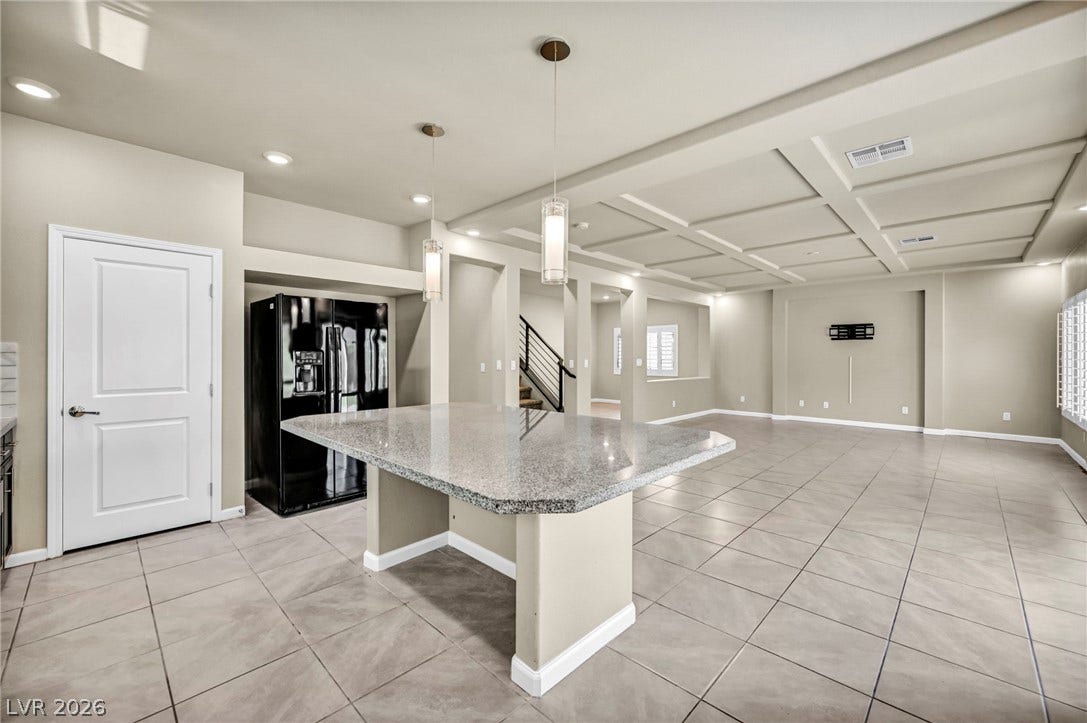 6571 Tangled Vines Avenue, Las Vegas, NV 89139 An open floorplan connects the central kitchen island to a spacious tile-floored living area.