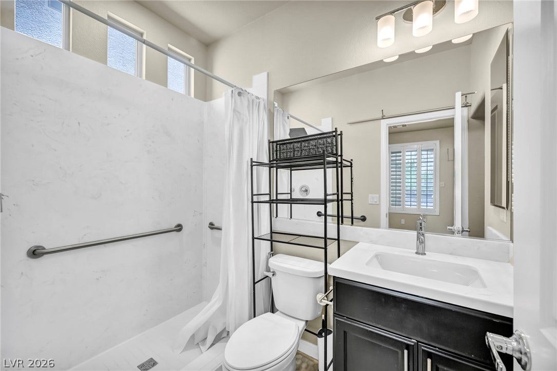 6571 Tangled Vines Avenue, Las Vegas, NV 89139 High ceilings and clean paneling elevate this functional, modern bathroom design.