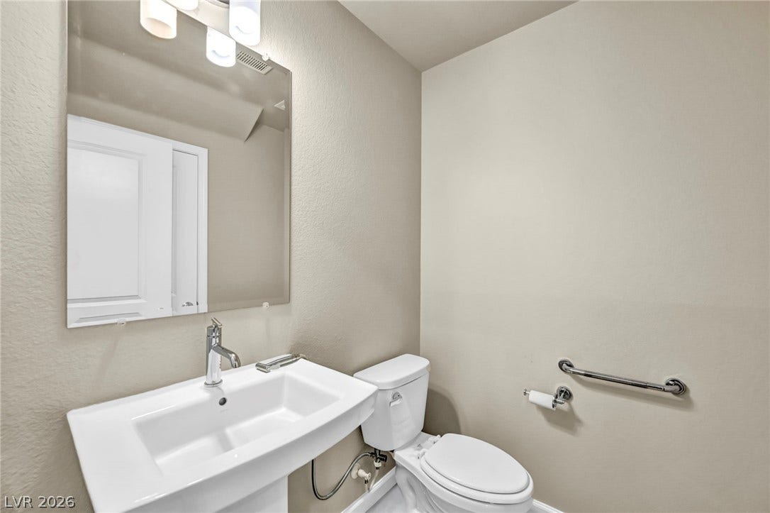 6571 Tangled Vines Avenue, Las Vegas, NV 89139 A clean powder room featuring a classic pedestal sink and modern safety grab bar.