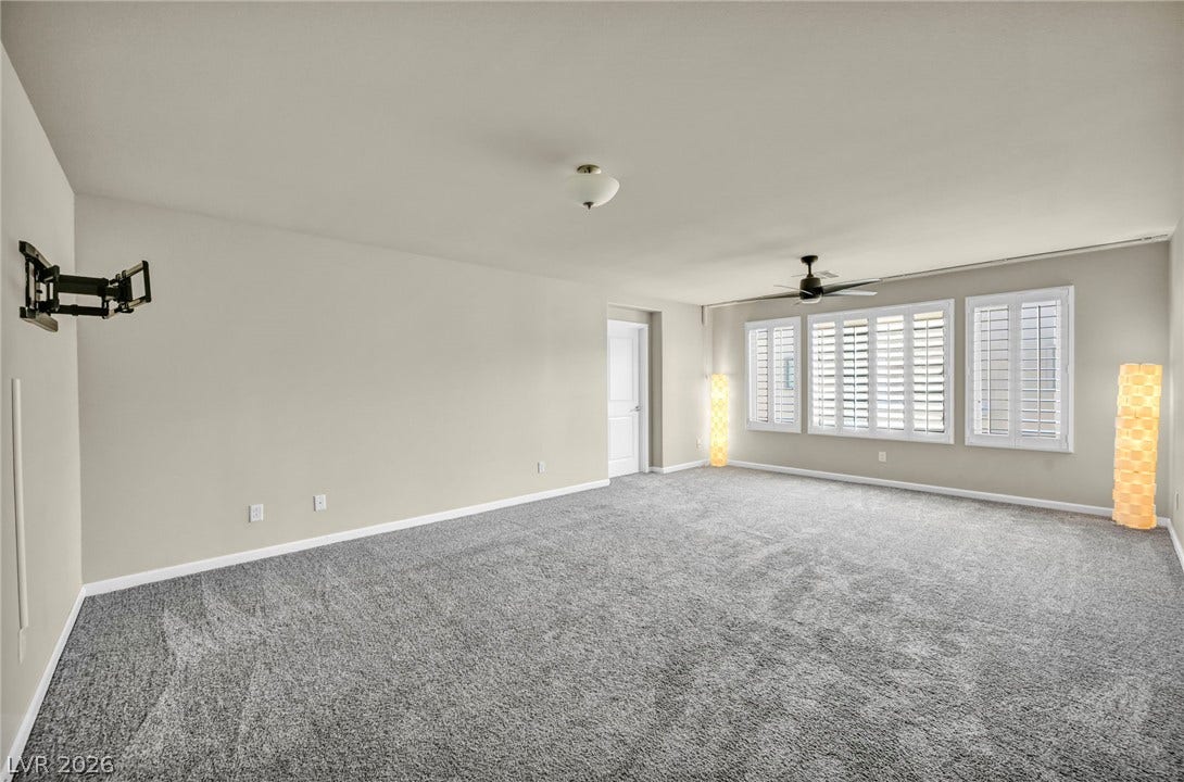 6571 Tangled Vines Avenue, Las Vegas, NV 89139 A spacious room features plush wall-to-wall carpeting and plantation shutters on the windows.