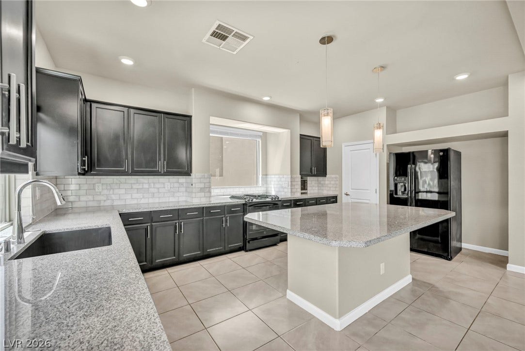 6571 Tangled Vines Avenue, Las Vegas, NV 89139 Polished granite countertops and classic subway tile backsplashes accent this modern culinary space.